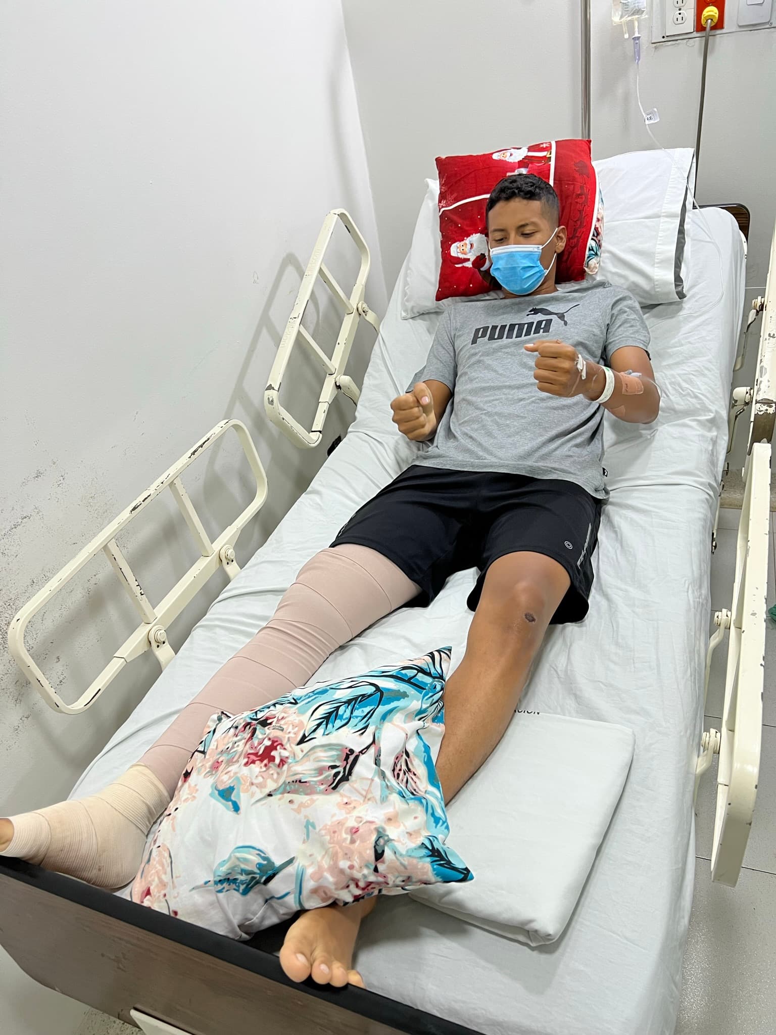 Juan en la cama del hospital, con la pierna enyesada